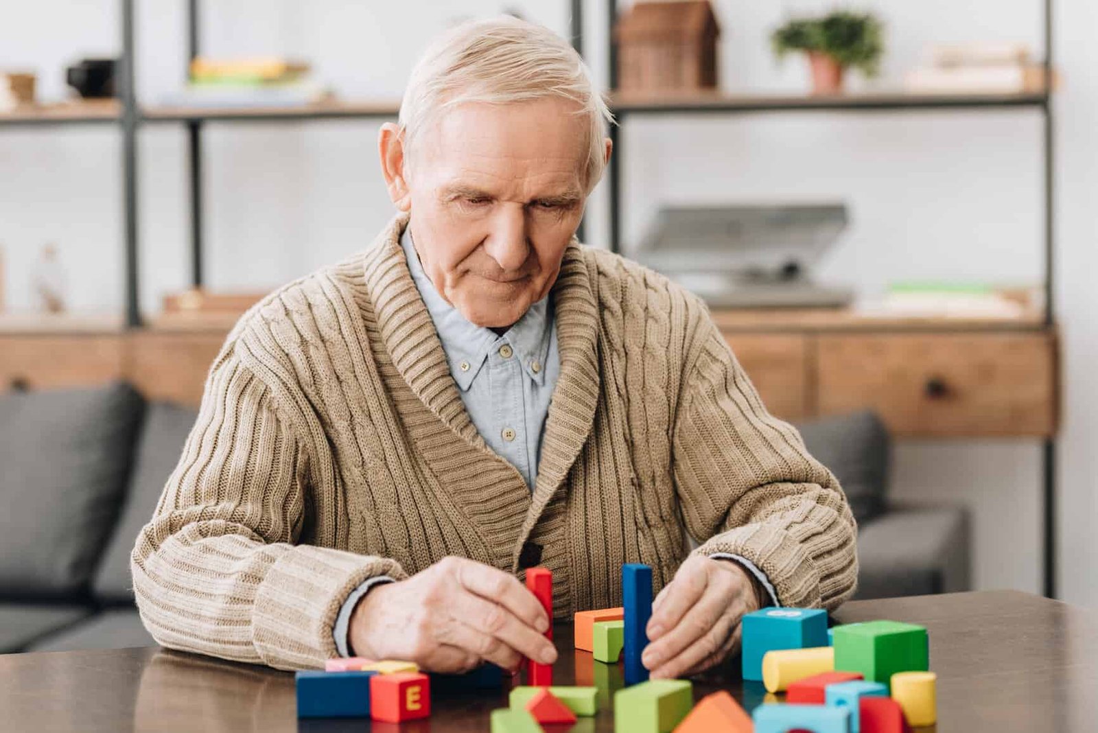 Senior man playing with wooden toys at home