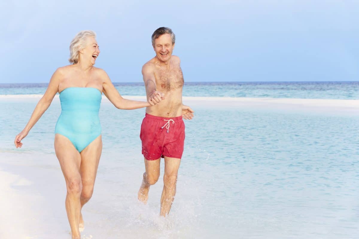 Senior Couple Splashing In Beautiful Tropical Sea