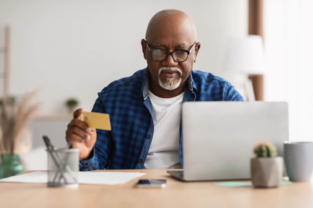 Senior Black Male Shopping With Credit Card Using Laptop Indoor