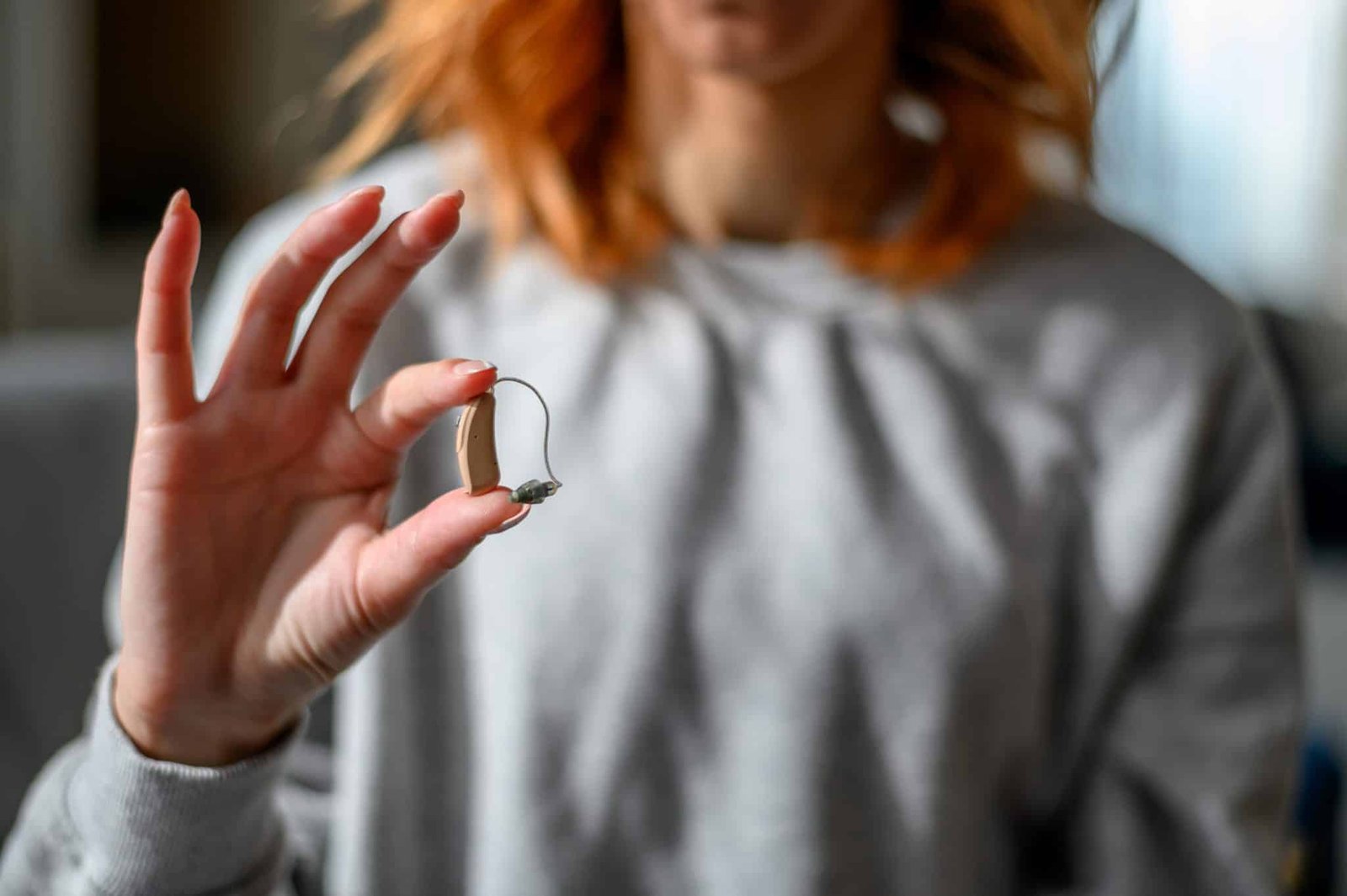 Woman hands holding a hearing aid