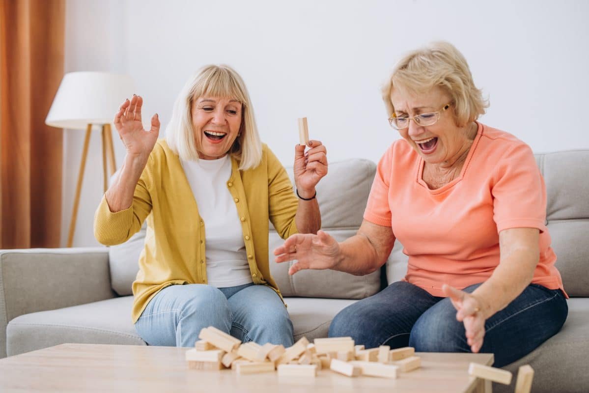 Two senior women female woman friends or family sisters play lei